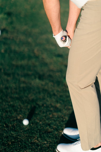 Person on a golf course holding a golf club with a blurred background