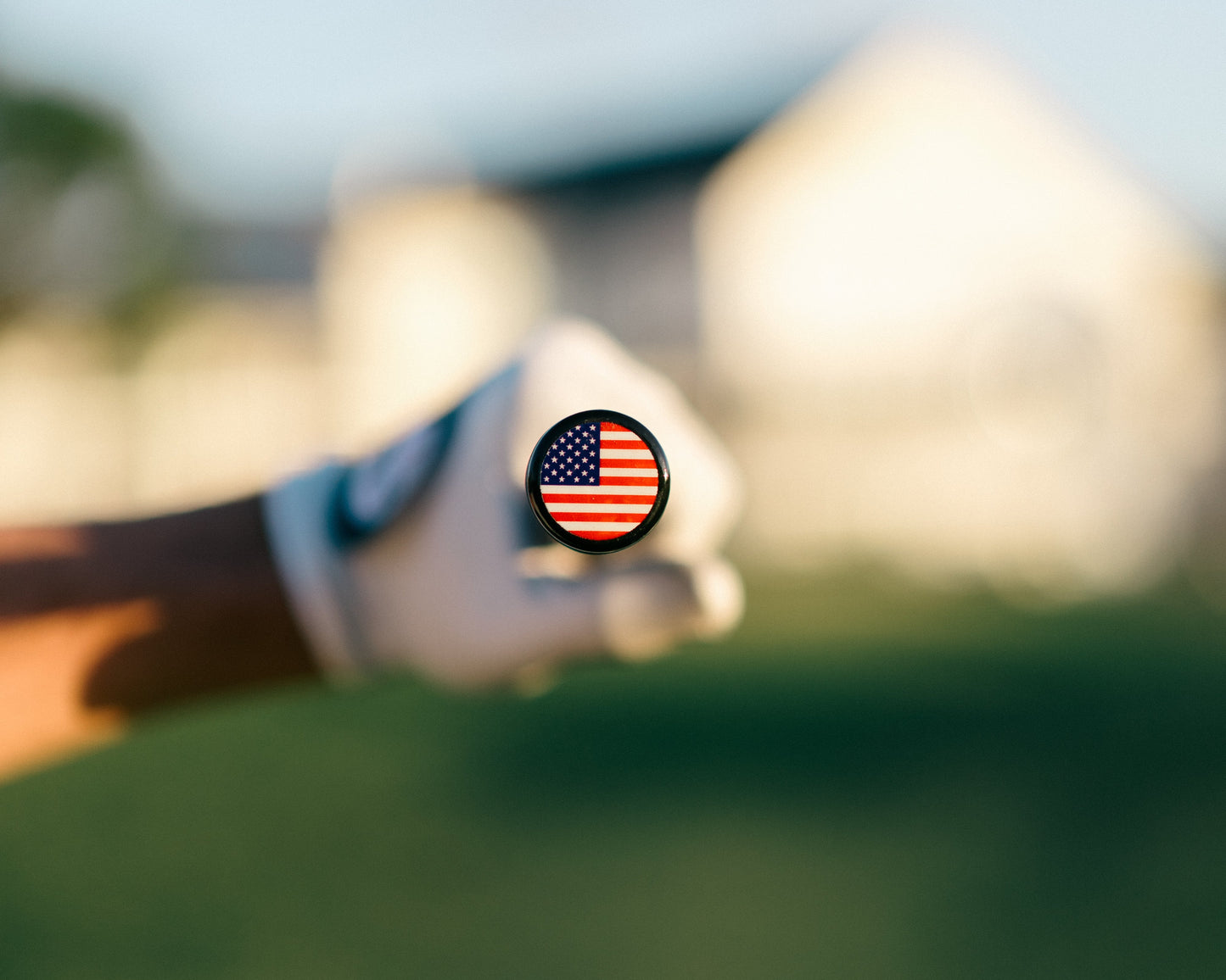 Golf club with an American flag Grip Topper on a blurred green golf course background